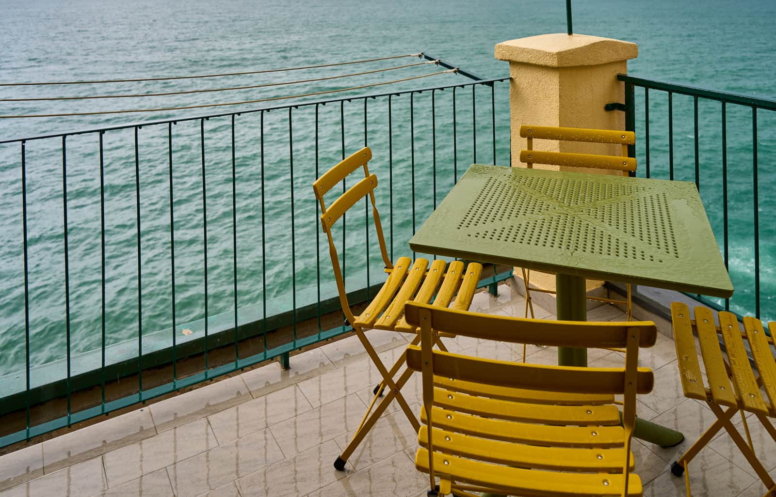 A small bistro table and two chairs on a balcony