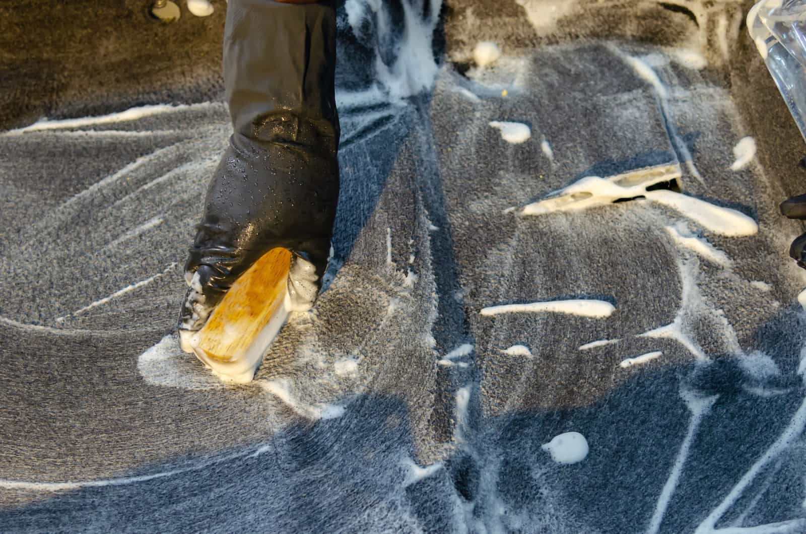 Cleaning supplies and a hose beside outdoor furniture