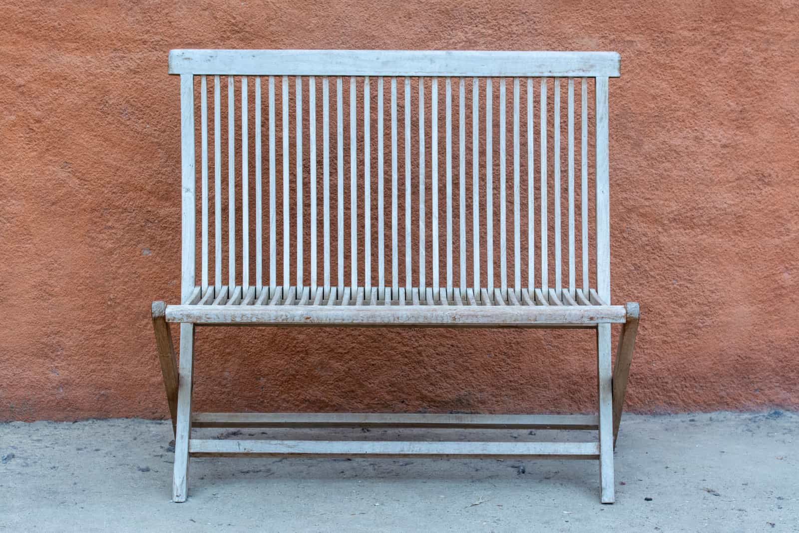 A teak garden bench weathered to a silver-gray patina