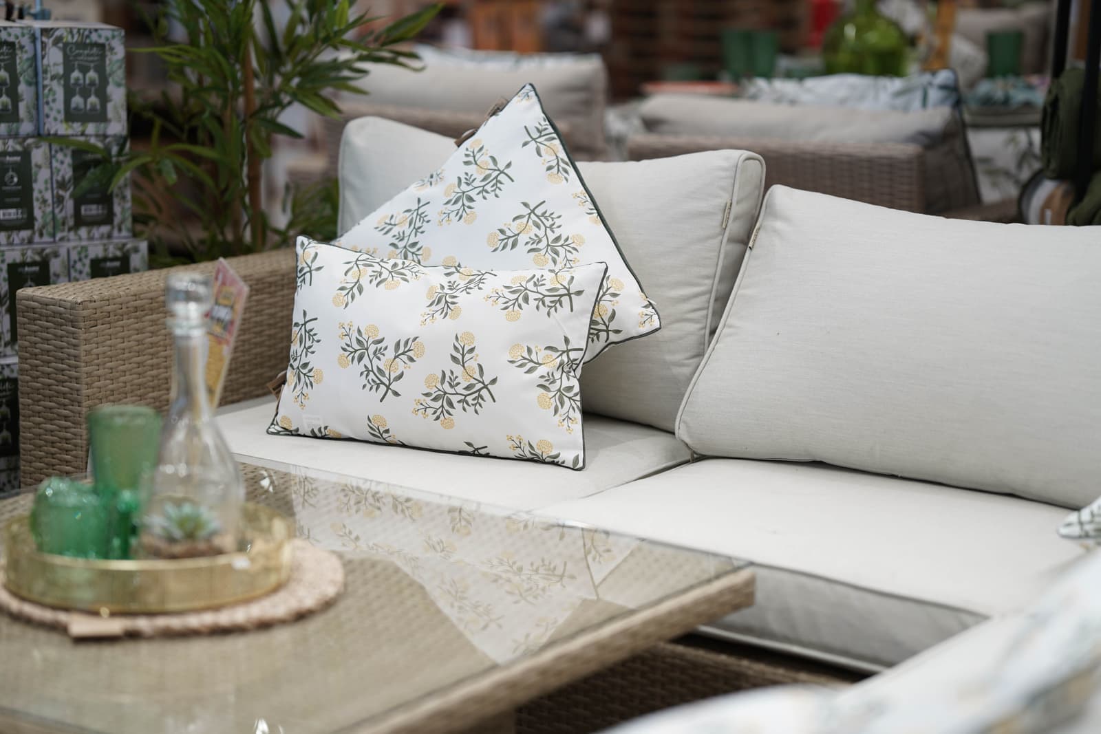 Gray all-weather wicker sectional with pale cushions on a deck
